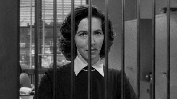 Balestrero is first seen by a teller through the grating of her booth.